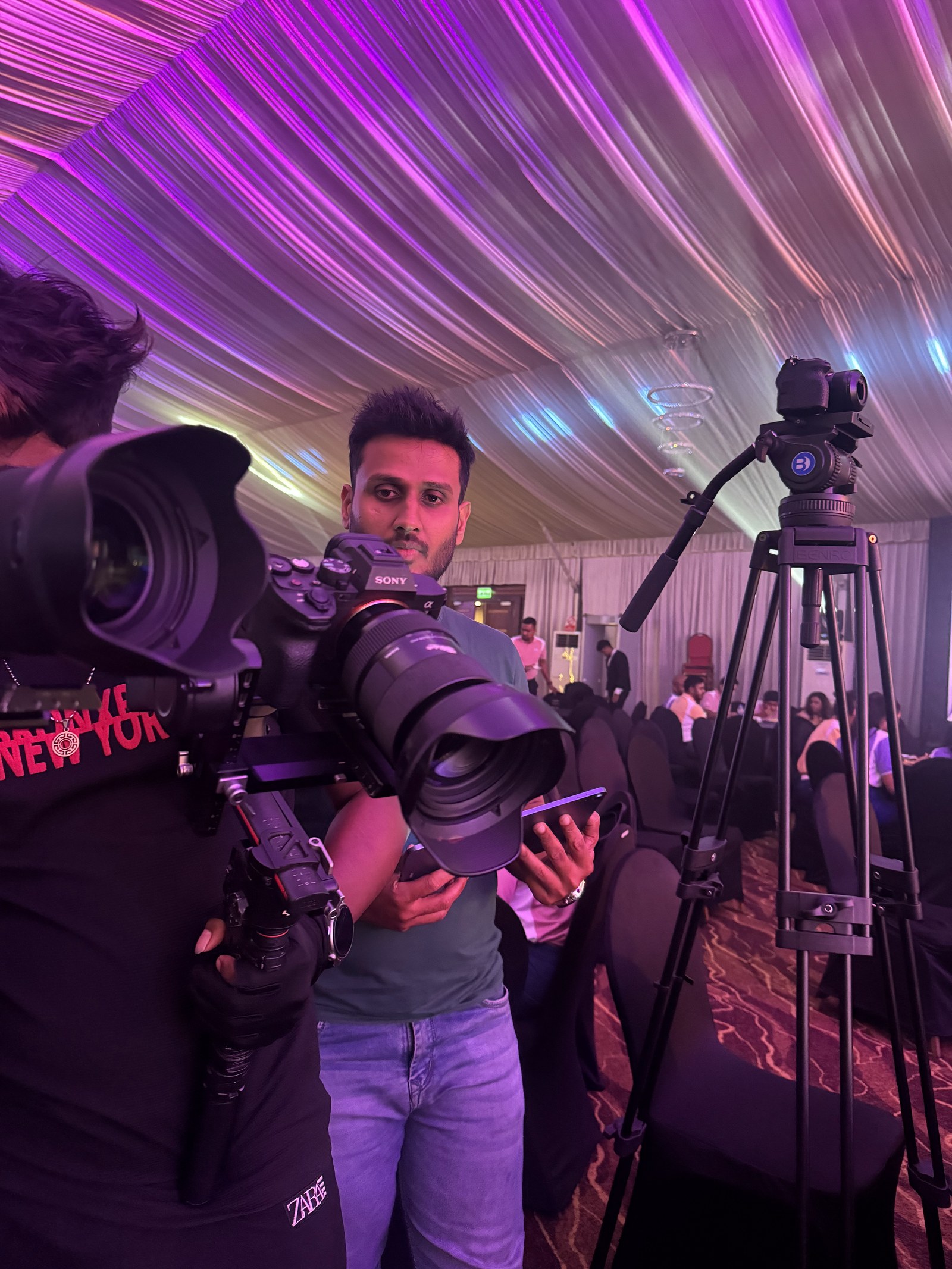 Camera operators with long-lens cameras covering a formal stage presentation