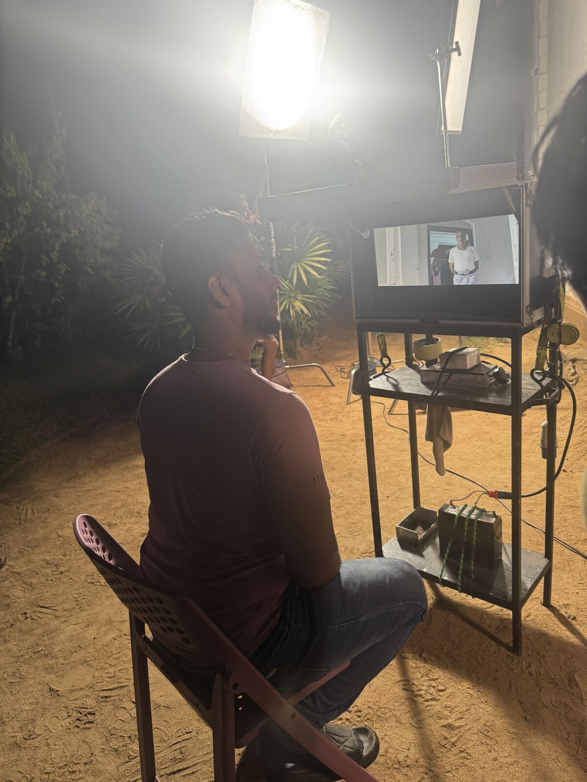 Director reviewing a take on a field monitor during a night shoot