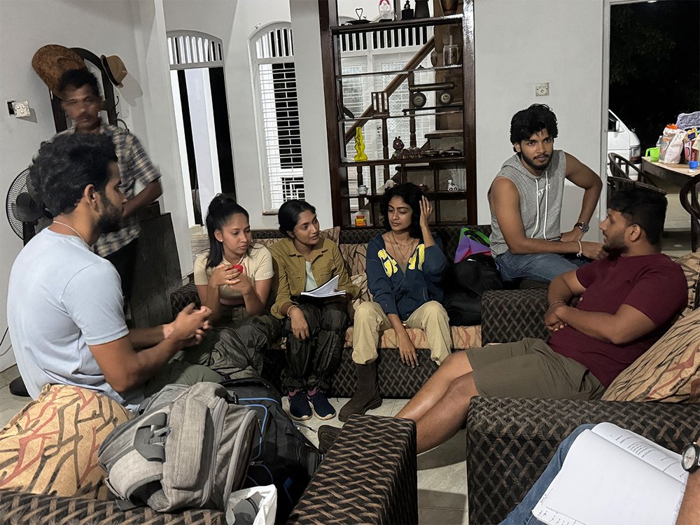 Cast and crew huddled for a night forest scene